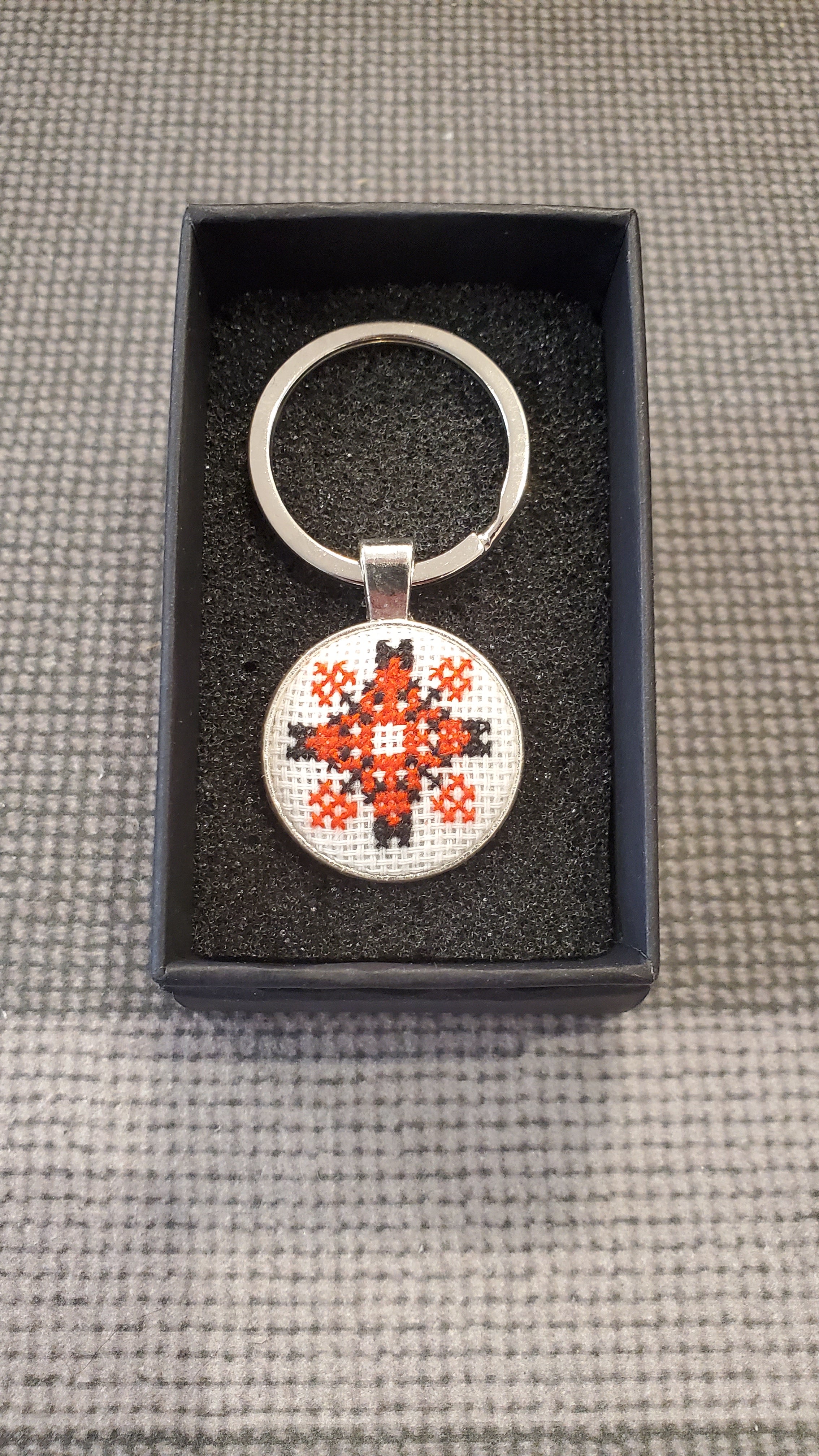 Keychain with micro-embroidered name codes