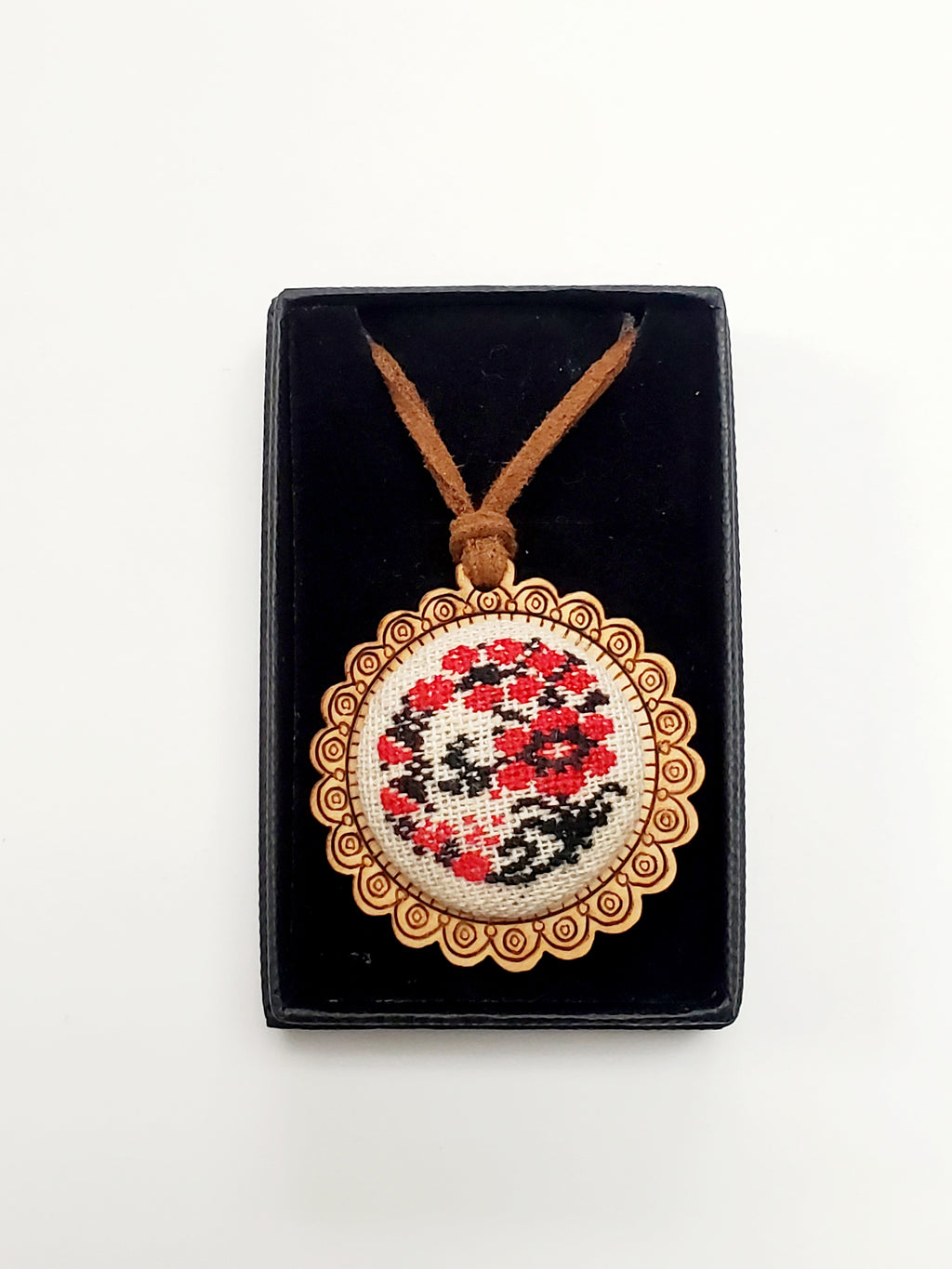 Wooden pendant on a rope with micro-embroidered name codes
