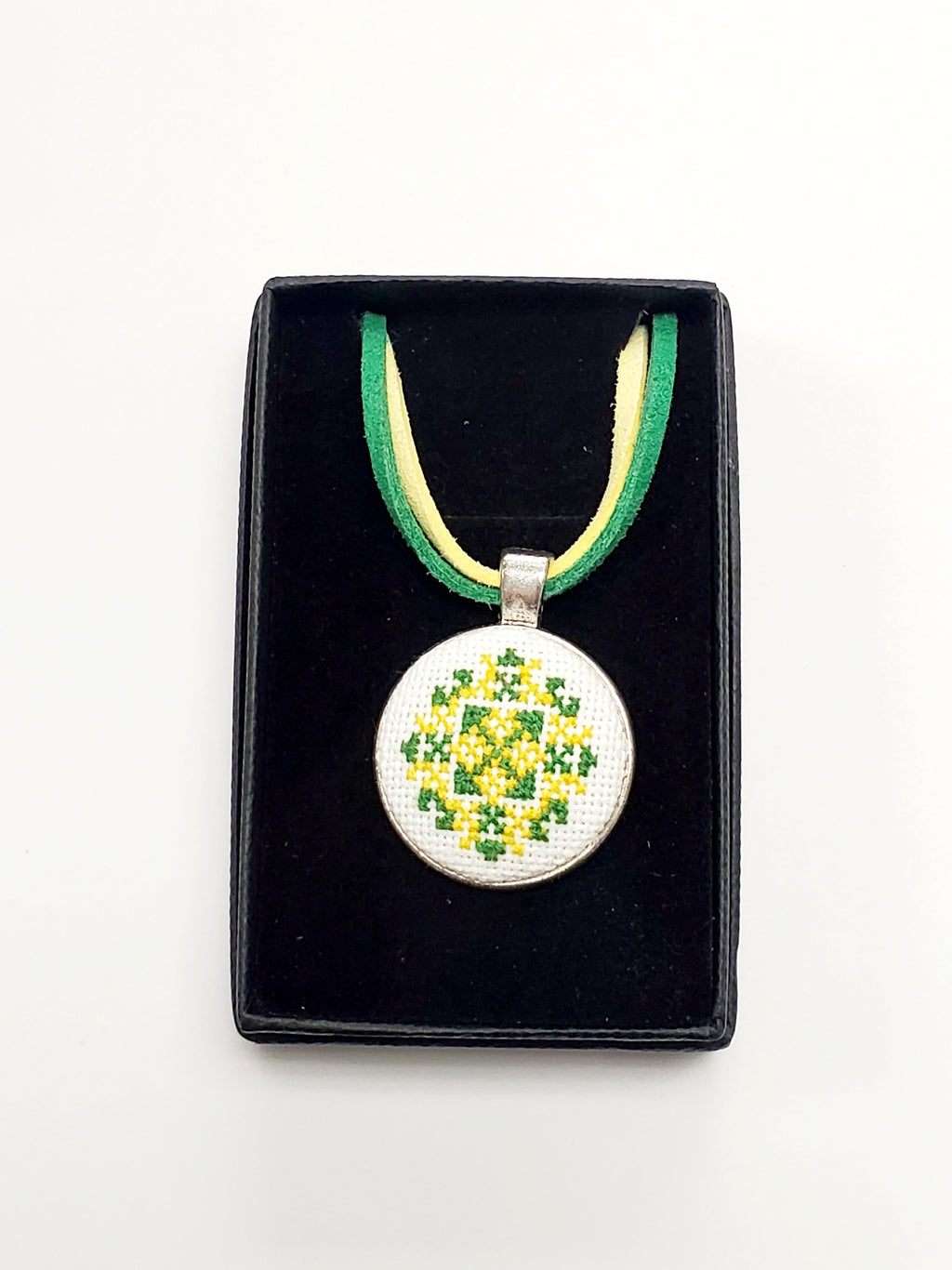 Metal pendant on a rope or chain which micro-embroidered name codes