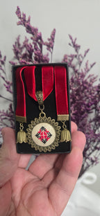 Metal pendant on a rope or chain which micro-embroidered name codes
