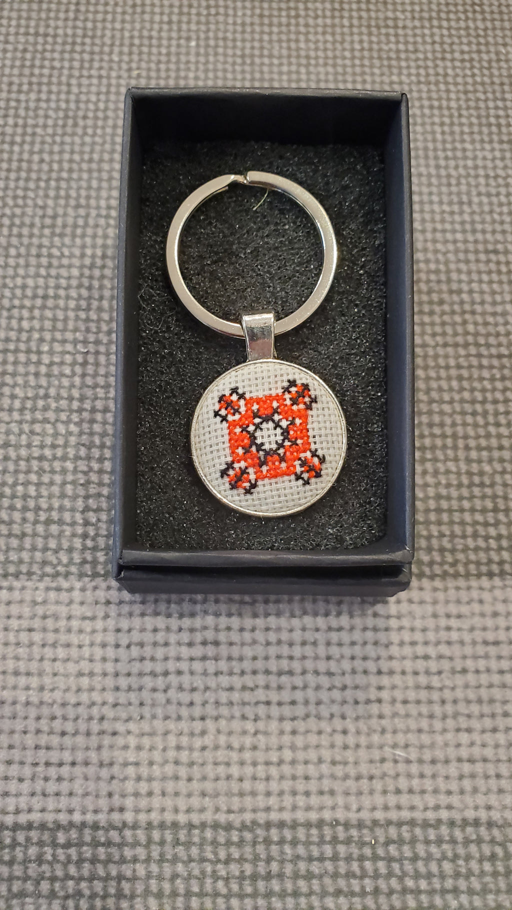 Keychain with micro-embroidered name codes