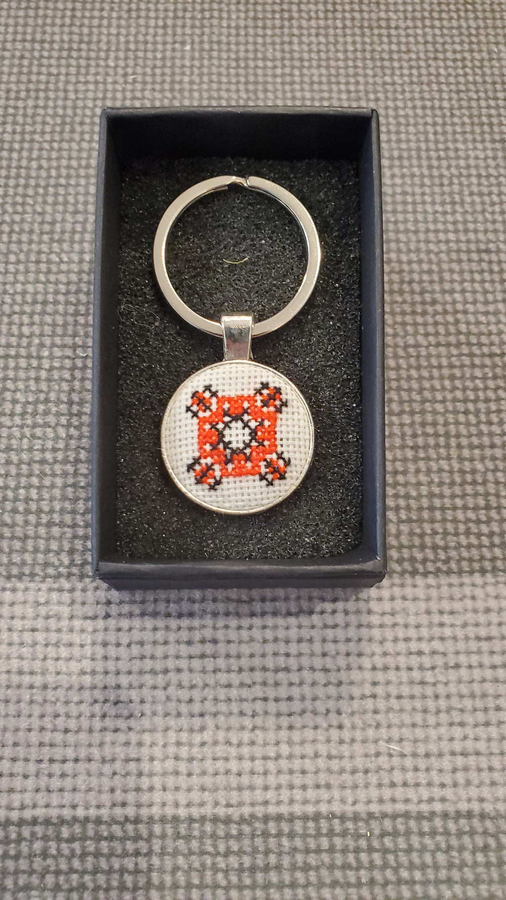 Keychain with micro-embroidered name codes